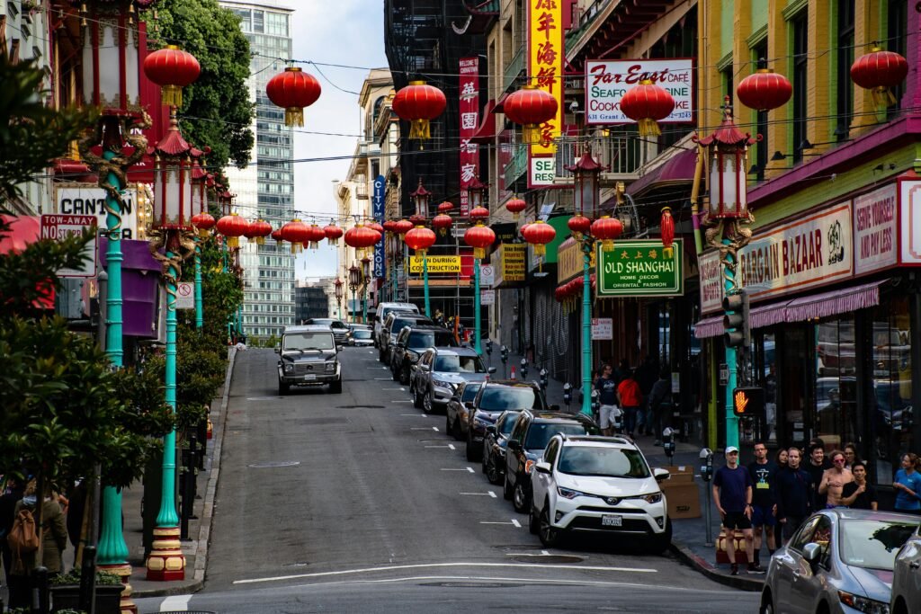 Vibrant Chinatown street scene with red lanterns, signage, and people walking.