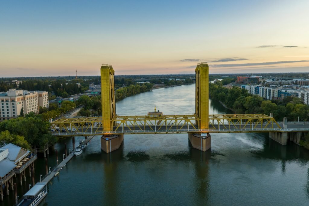 Stunning aerial view of the Tower Bridge in Sacramento during sunset, reflecting on the river.