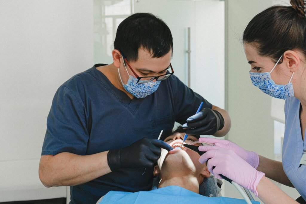 Two dental professionals conducting a dental check-up on a patient in a modern clinic.