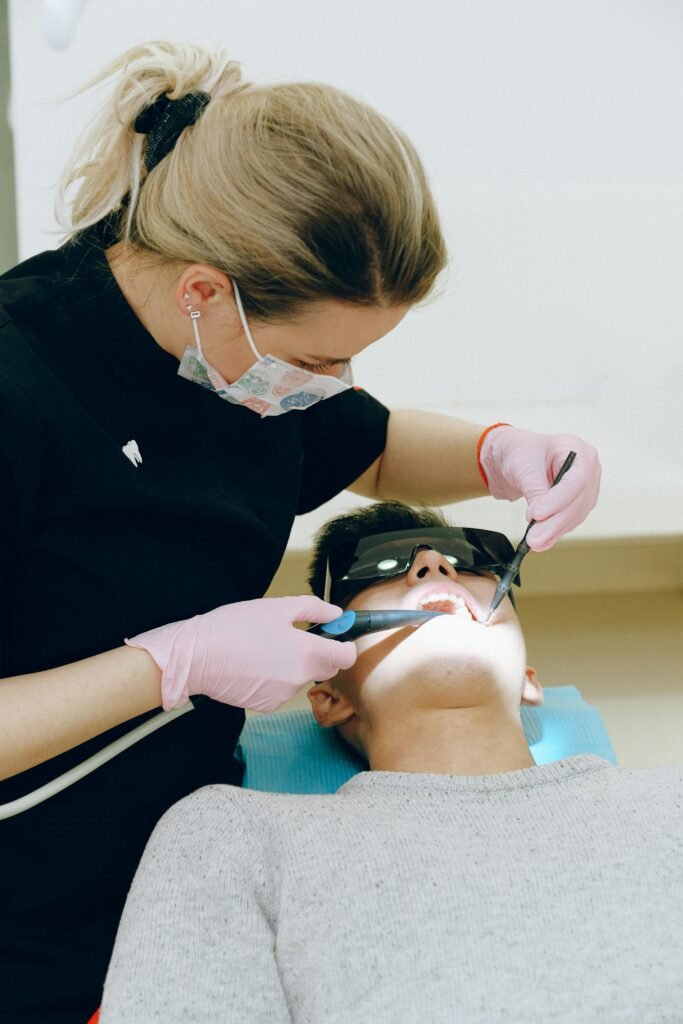 Dentist performing a dental check-up on a patient in a clinic, ensuring oral health.